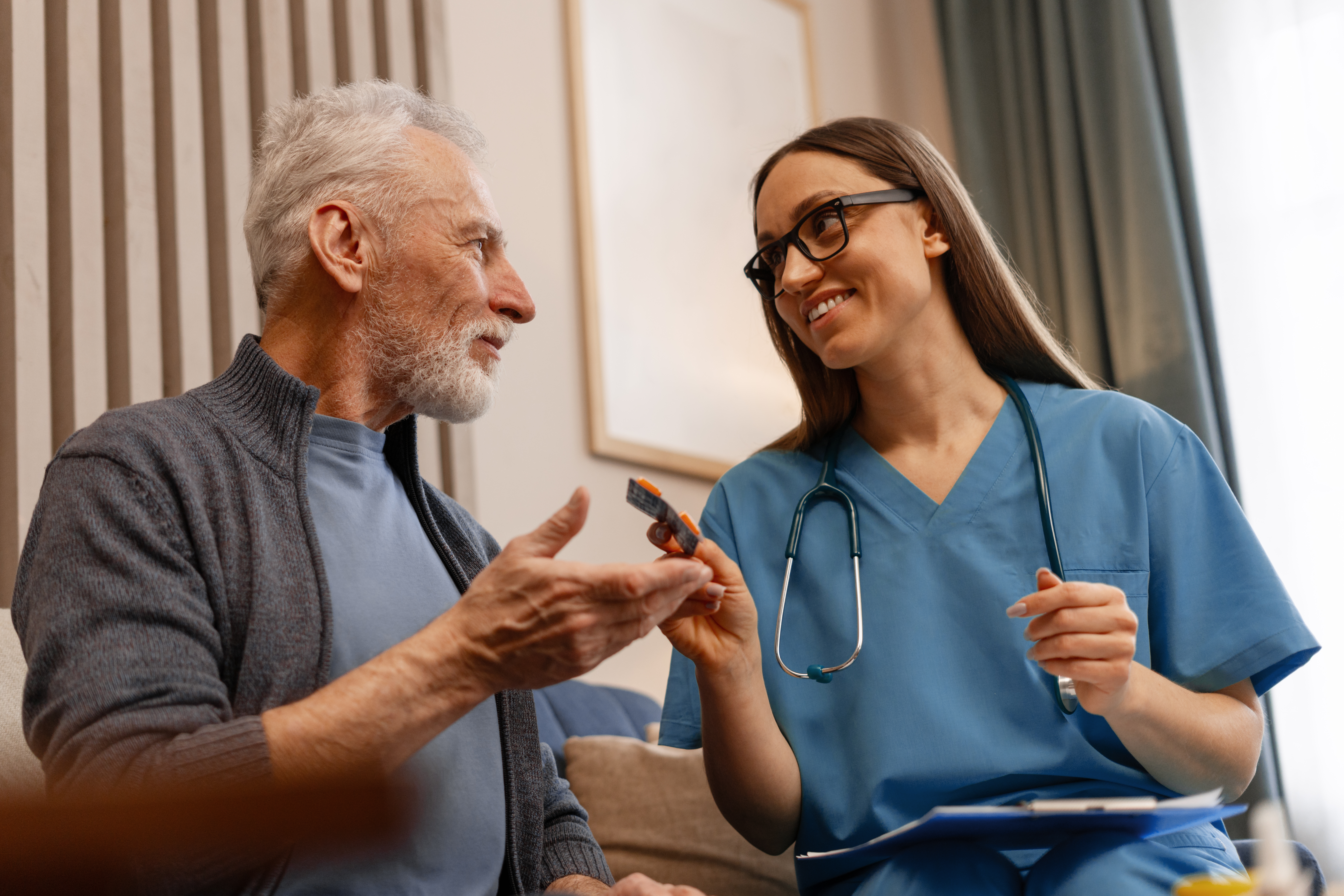 Psychiatric mental health clinician explaining medication dosage to an older patient during a home visit